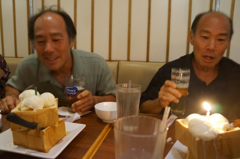 Of course they are holding their beers while blowing out the candles! 